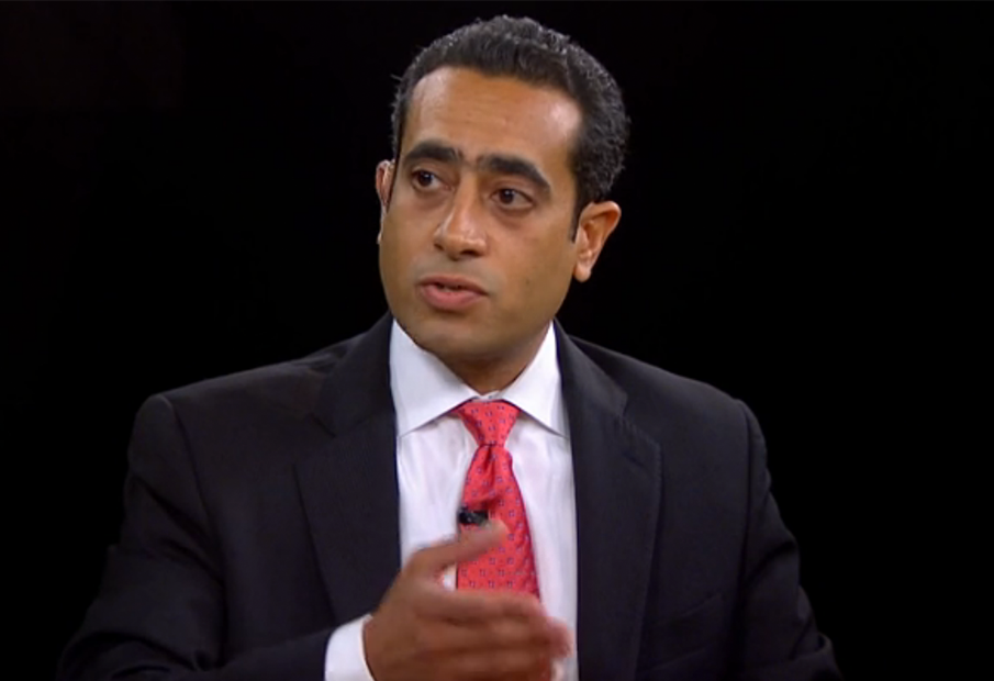a man in a suit and tie sitting down