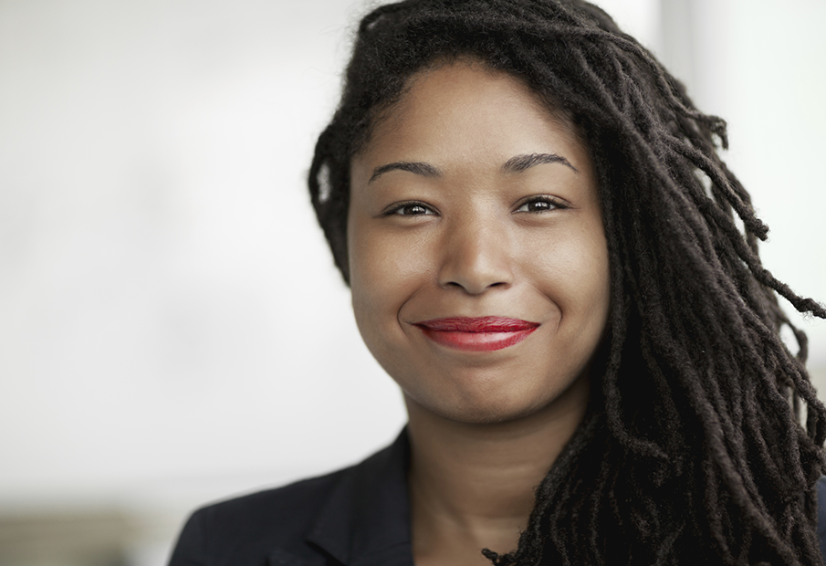 a woman with dreadlocks smiling at the camera