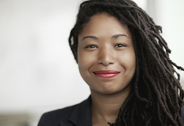 a woman with dreadlocks smiling at the camera