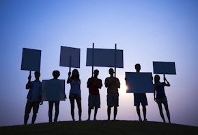 Seven people with white signs