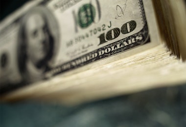 Stack of bills with a $100 bill on top