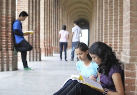 A few students sitting and reading in a hall