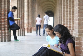 A few students sitting and reading in a hall