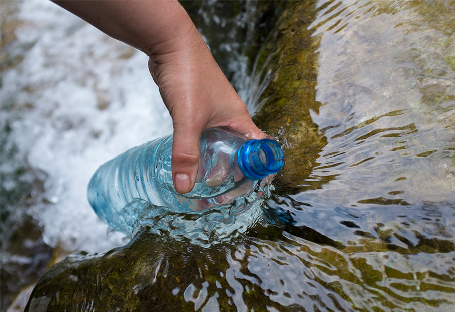 a person is holding a water bottle in the water