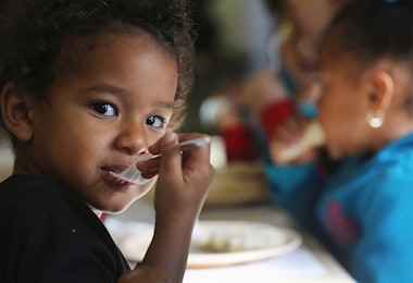 A todler with a plastic fork in their mouth