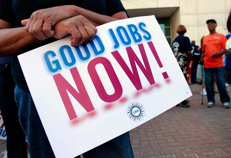 a person holding a sign that says good jobs now