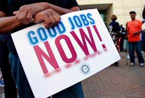 a person holding a sign that says good jobs now