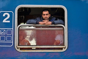 a man looks out the window of a train