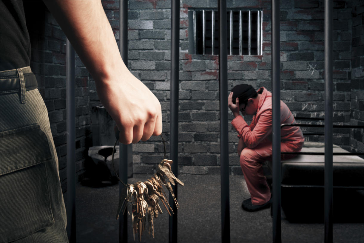 a man sitting on a bench in a jail cell
