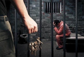 a man sitting on a bench in a jail cell