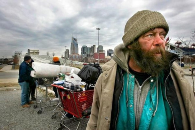 -

- Homeless man John Wayne and others wait in a parking lot near LP Field after Metro police had them move their possessions from under the Shelby Street Bridge. Wayne said police have been nice about giving them time to move. A recent count by a national organization found 1,542 homeless people living in Nashville in January 2005. -

-.JOHN PARTIPILO/THE TENNESSEAN