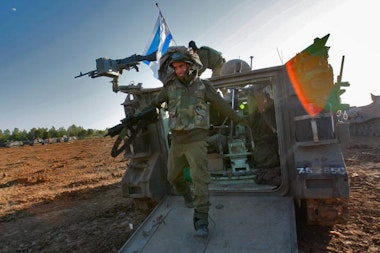 GAZA BORDER, ISRAEL - JANUARY 13:  An Israeli soldier dismounts from an APC after returning from fighting against Hamas militants in the Gaza Strip on January 13, 2009 at a forward deployment area on Israel's border with the Palestinian territory. Israel is intensifying its wide-scale ground assault against the Gaza Strip in an effort to put an end to Hamas rocket attacks against the Jewish State.  (Photo by David Silverman/Getty Images)
