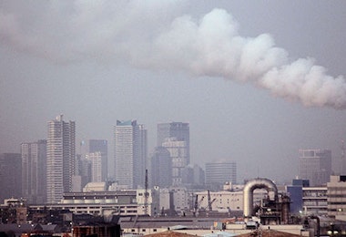 smoke billows from a factory in a city
