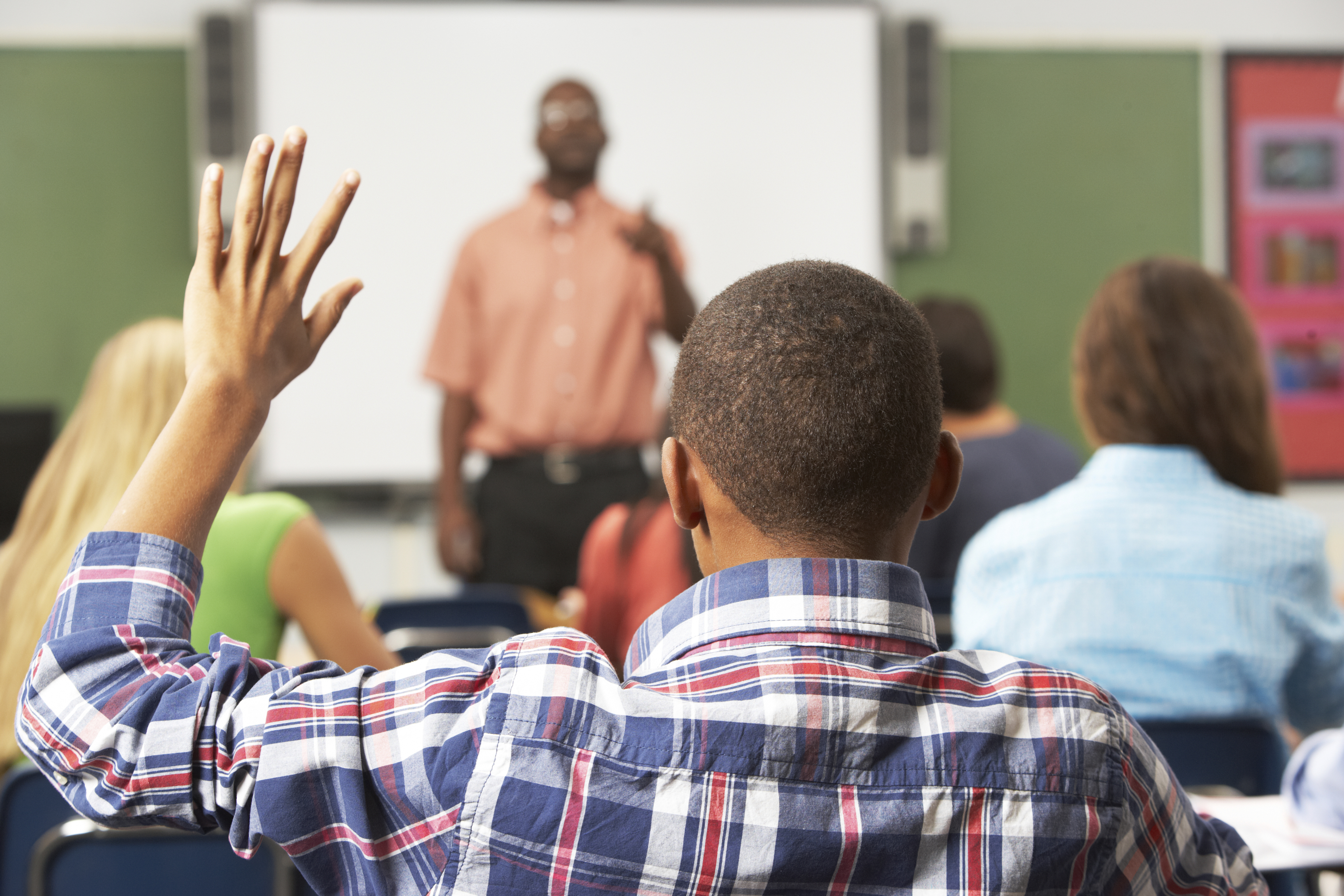 Male Pupil Raising Hand In Class