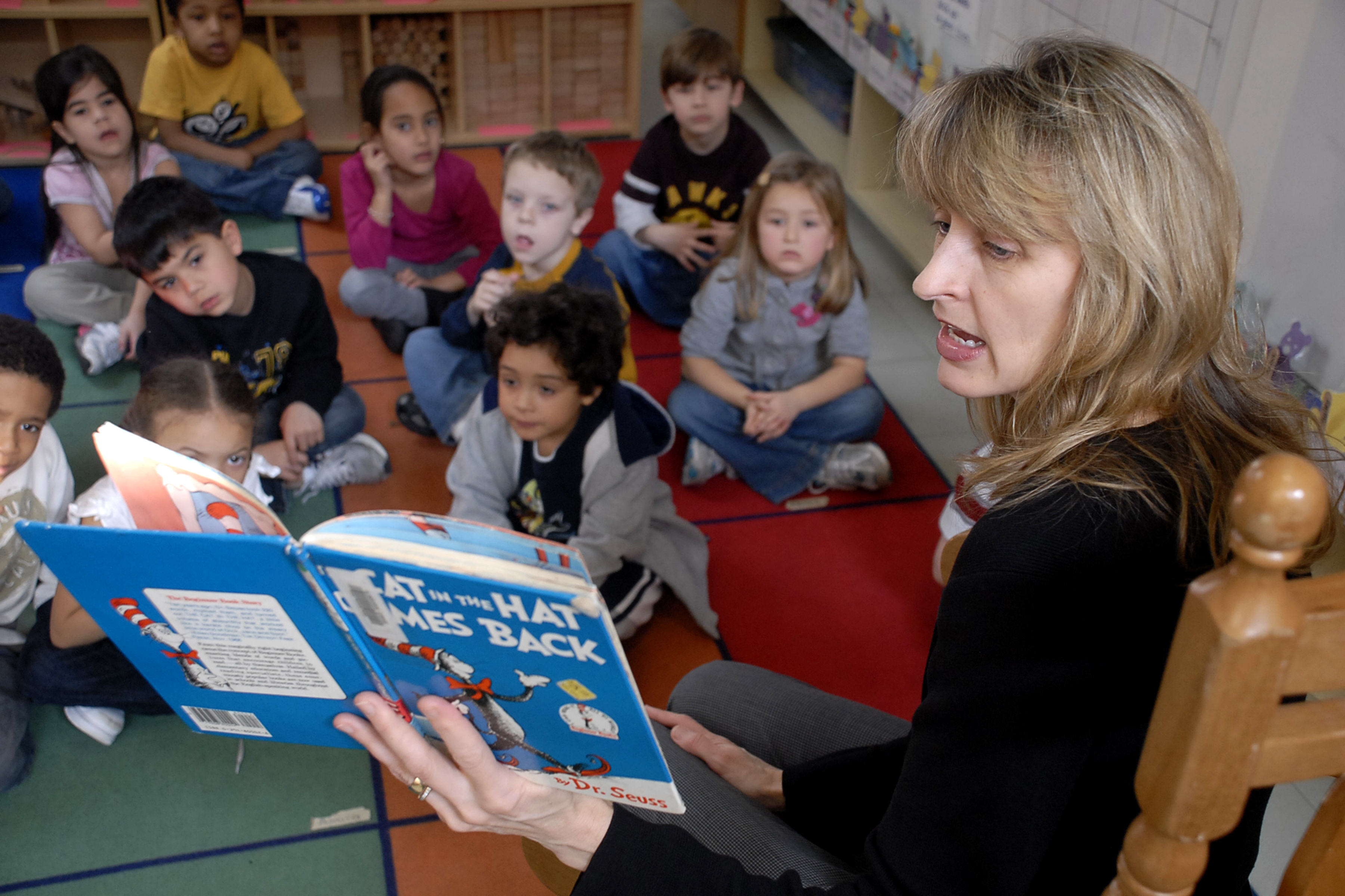 A woman reading Dr. Seuss to a classroom of children