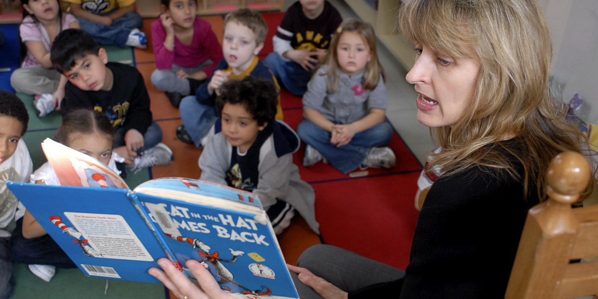 A woman reading Dr. Seuss to a classroom of children