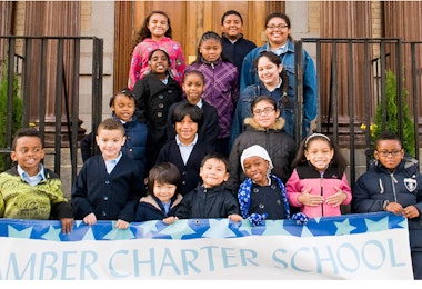 a group of children standing in front of a buildingf
