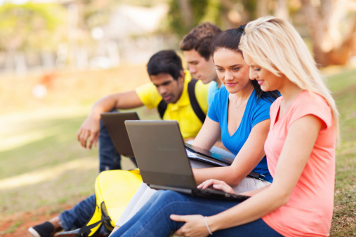 group of college students using laptop computers