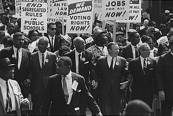 a large group of people marching down a street