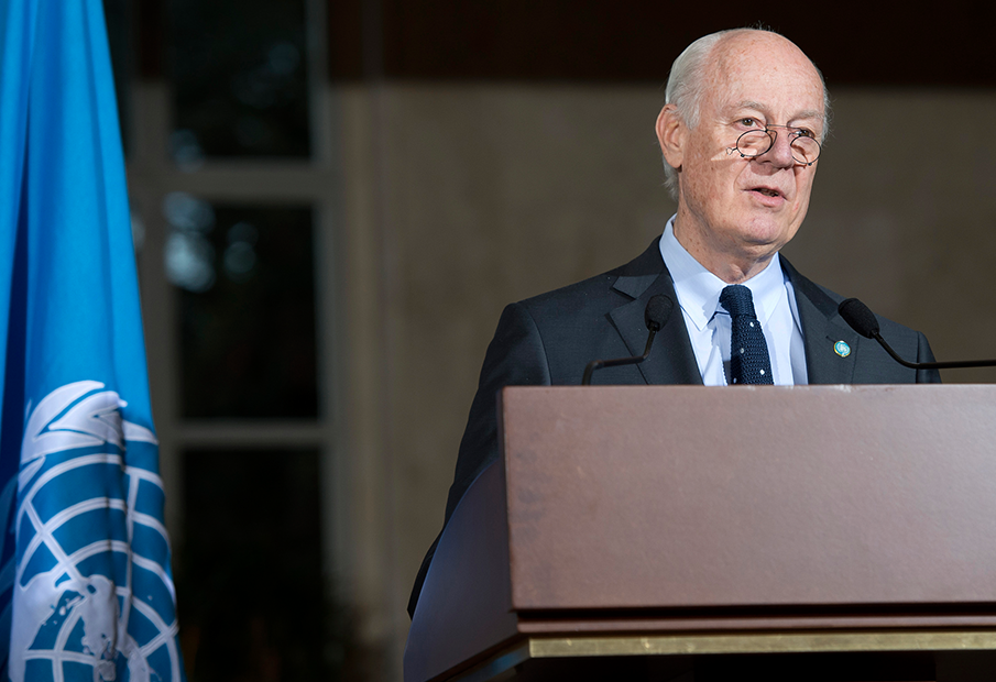 a man in a suit and tie standing at a podium