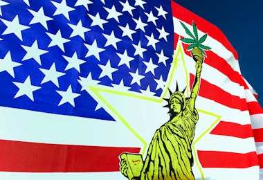 A yellow Statue of Liberty on top of an American flag