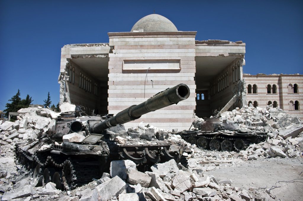 Two destroyed tanks in front of a mosque in Azaz, Syria. A battle between the Free Syrian Army (FSA) and the Syrian Arab Army (SAA) was fought for control over the city of Azaz, north of Aleppo, during the Syrian civil war. Source: Christiaan Triebert.