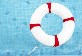 Life Ring at the swimming pool. Life Ring on water. Life Ring on blue water.