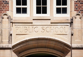 A Public School sign carved in granite about the entrance to an old high school.