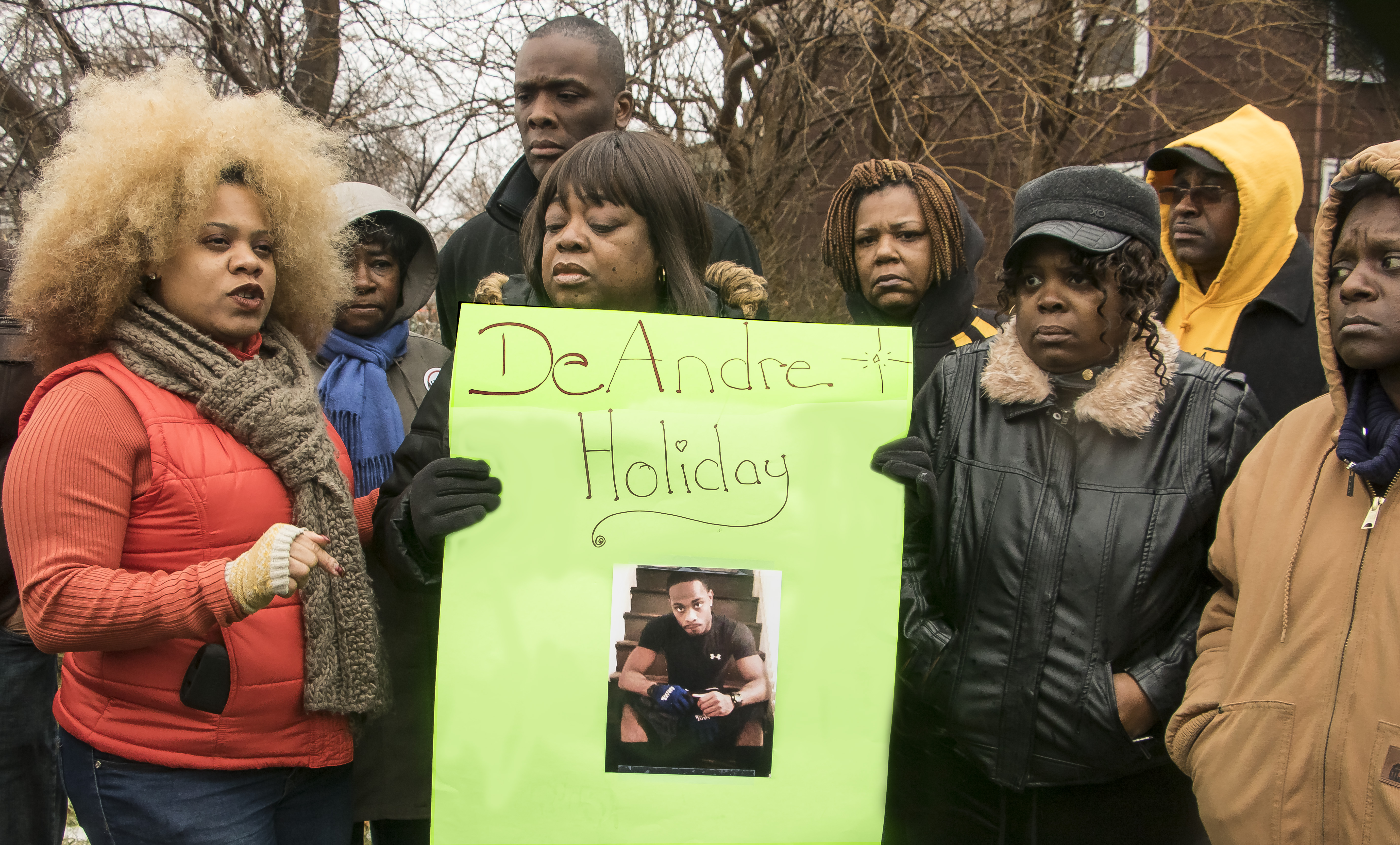 a group of people holding a sign with a picture on it