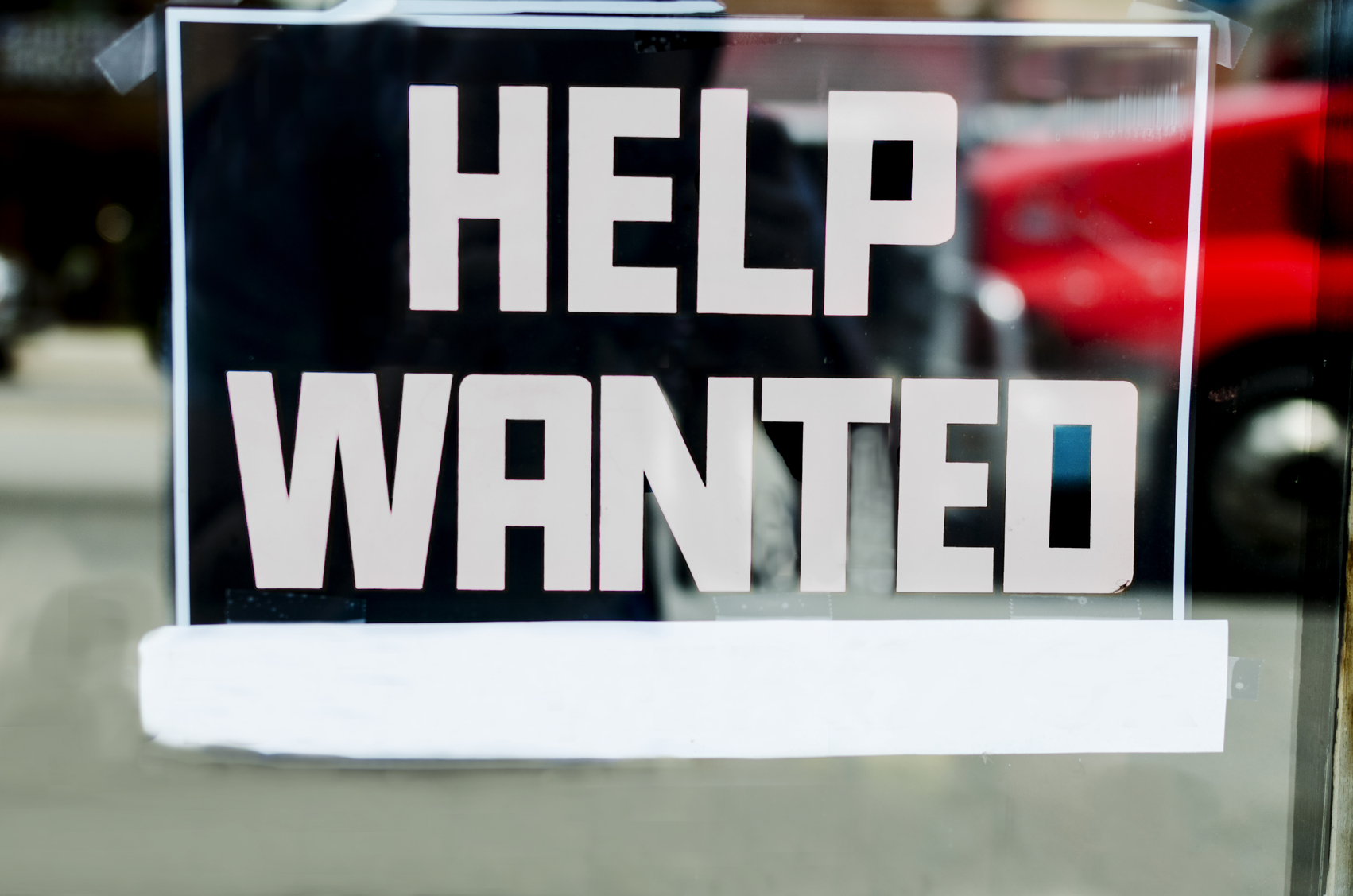 Help wanted sign outside of a store in the United States.