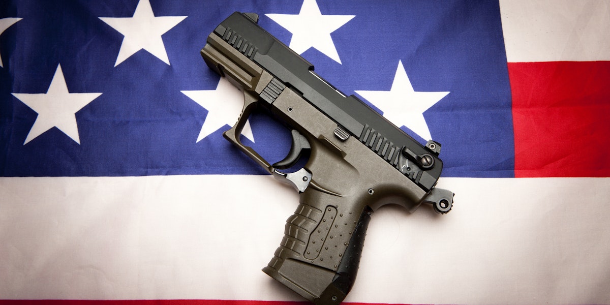 A concept image of liberty showing a pistol  on the American flag,