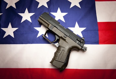 A concept image of liberty showing a pistol  on the American flag,