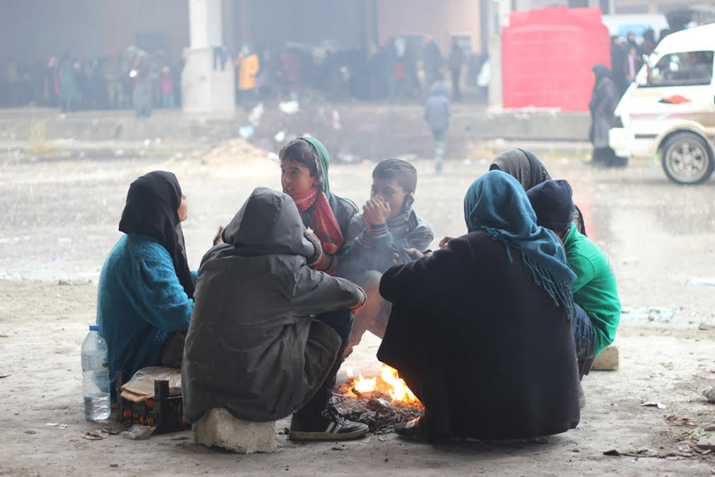 a group of people sitting around a fire