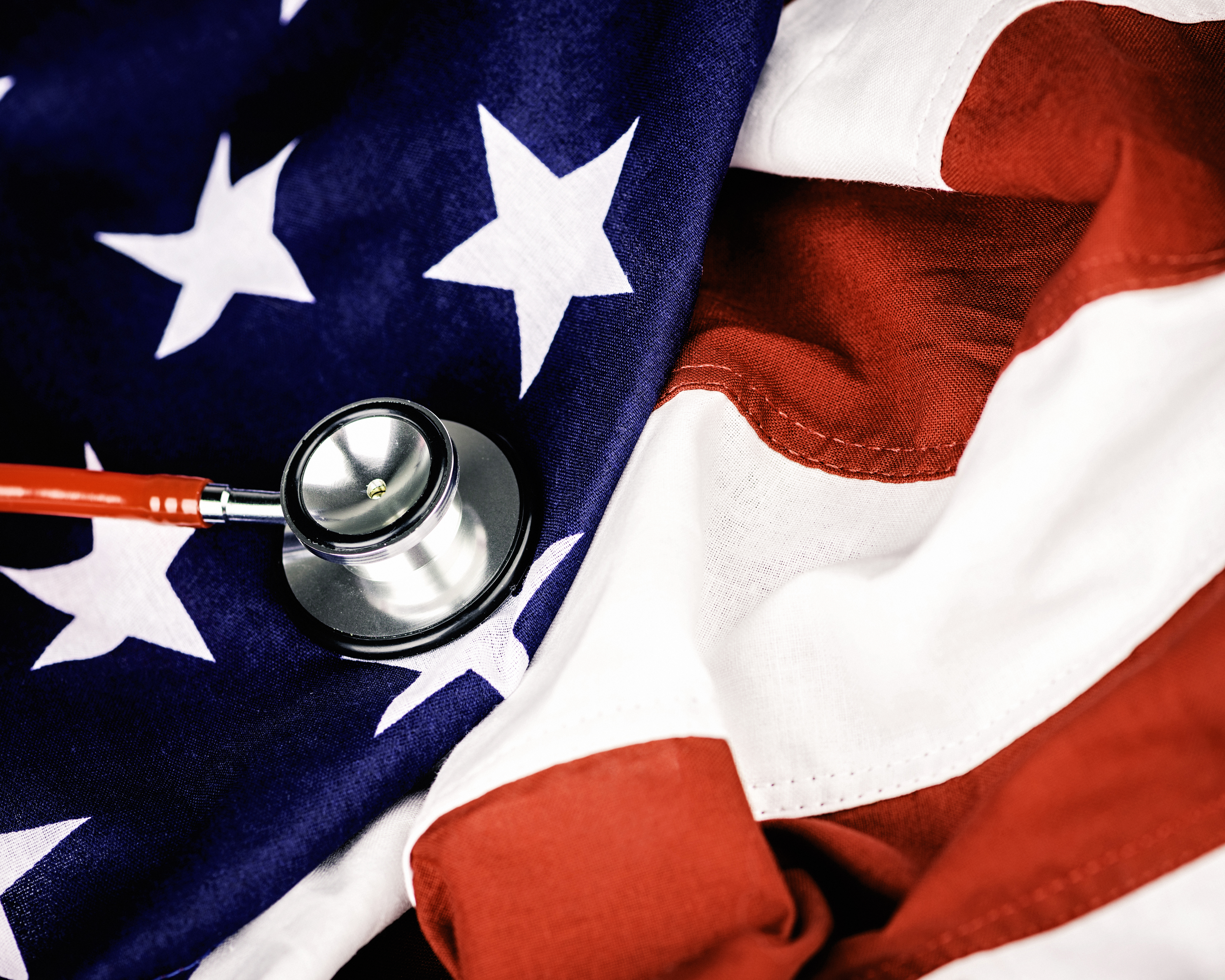 Red stethoscope on top of an American flag
