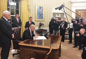 Photograph of President Trump signing a document.