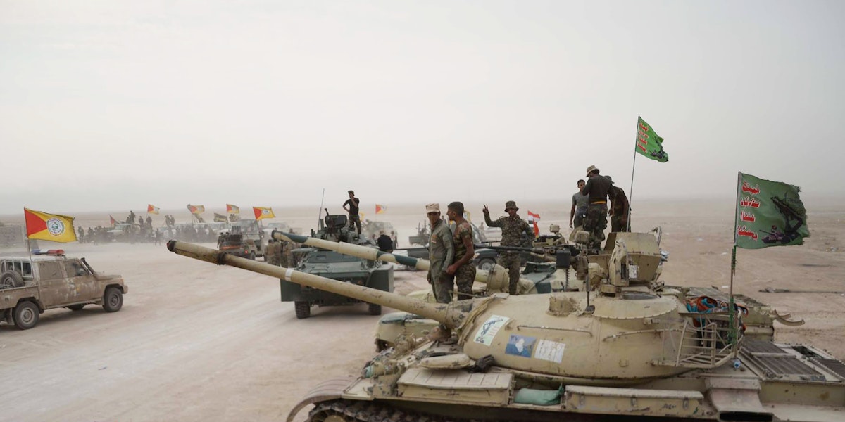 A photograph of military tanks and soldiers in the middle east