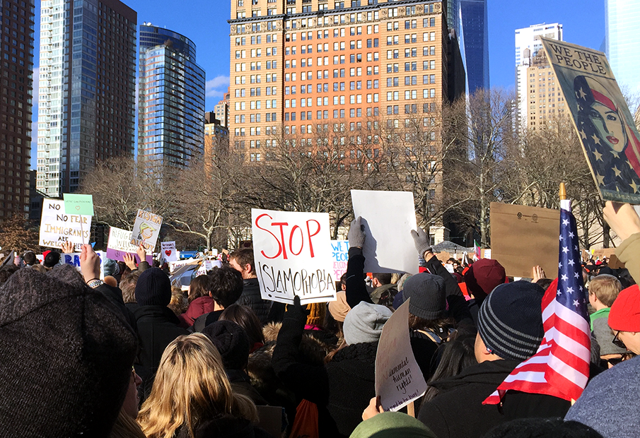 Photograph of a rally with the signs saying stop Islamphobia