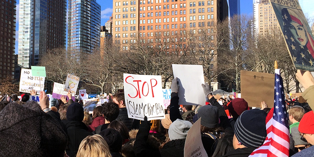 Photograph of a rally with the signs saying stop Islamphobia