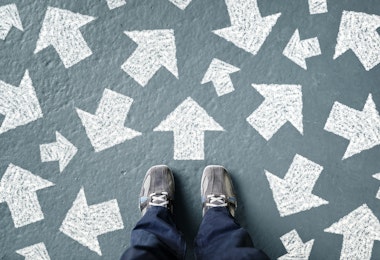 Taking decisions for the future man standing with many direction arrow choices, left, right or move forward