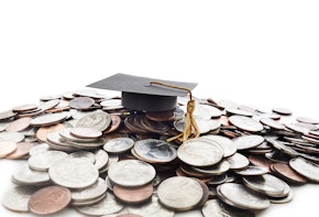 Graduation cap on a pile of money -- student loan concept