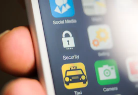 Hand holding phone, security app on screen.