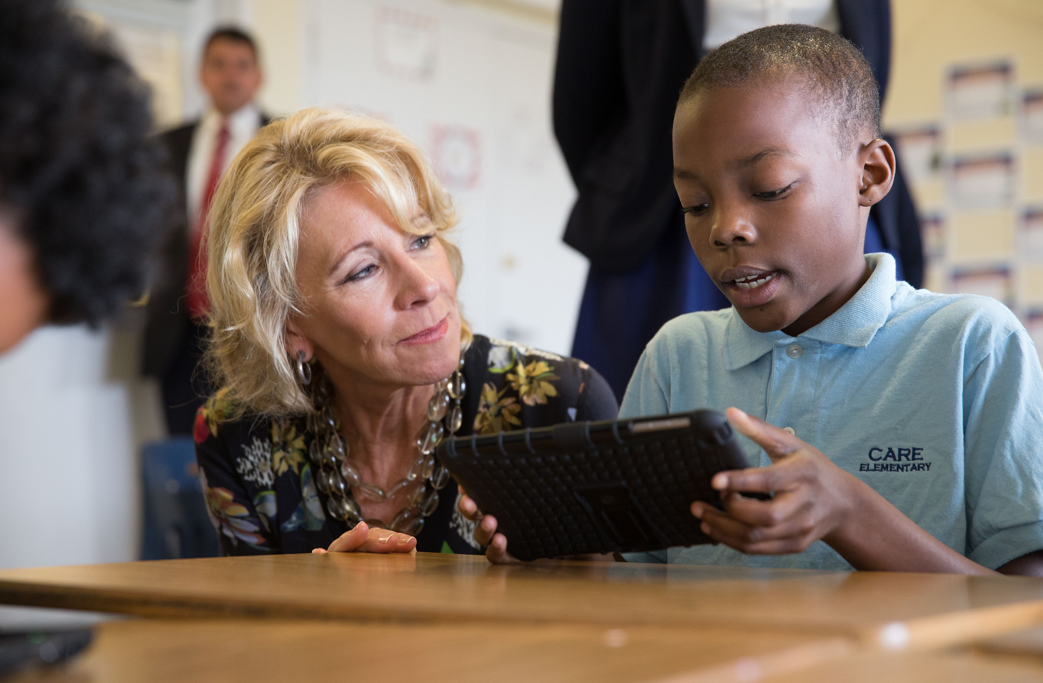 a woman and a boy are looking at a tablet