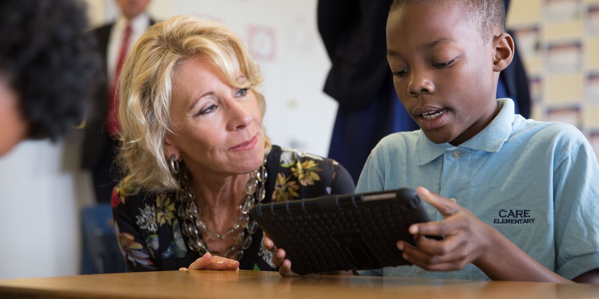 a woman and a boy are looking at a tablet