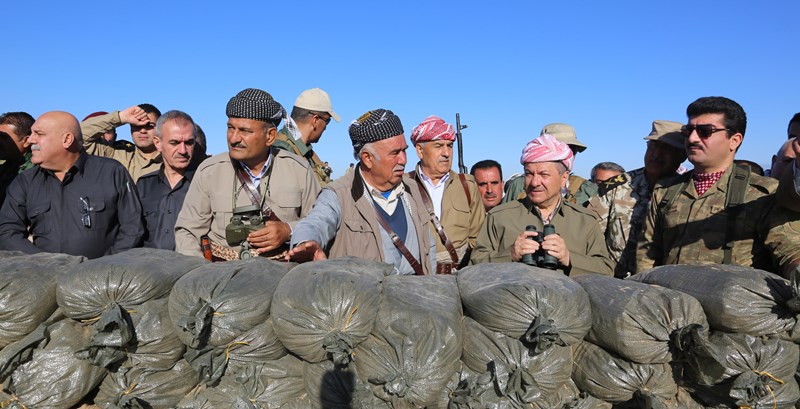 Masoud Barzani and other men dressed in military uniform