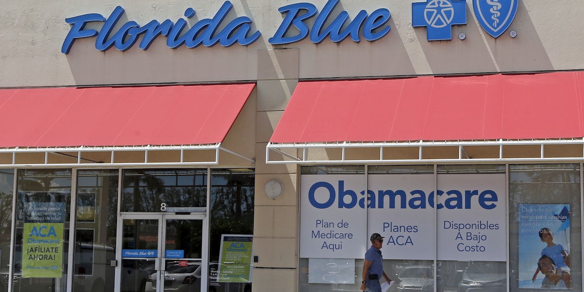 FILE - In this Thursday, July 27, 2017, file photo, a person walks by a health care insurance office in Hialeah, Fla. Health insurance shoppers will face a new deadline, rising prices and fewer options for help in many markets when the Affordable Care Act’s main enrollment window for 2018 coverage opens Wednesday, Nov. 1. Insurance experts say those who need insurance should avoid waiting to do last-minute shopping. (AP Photo/Alan Diaz, File)