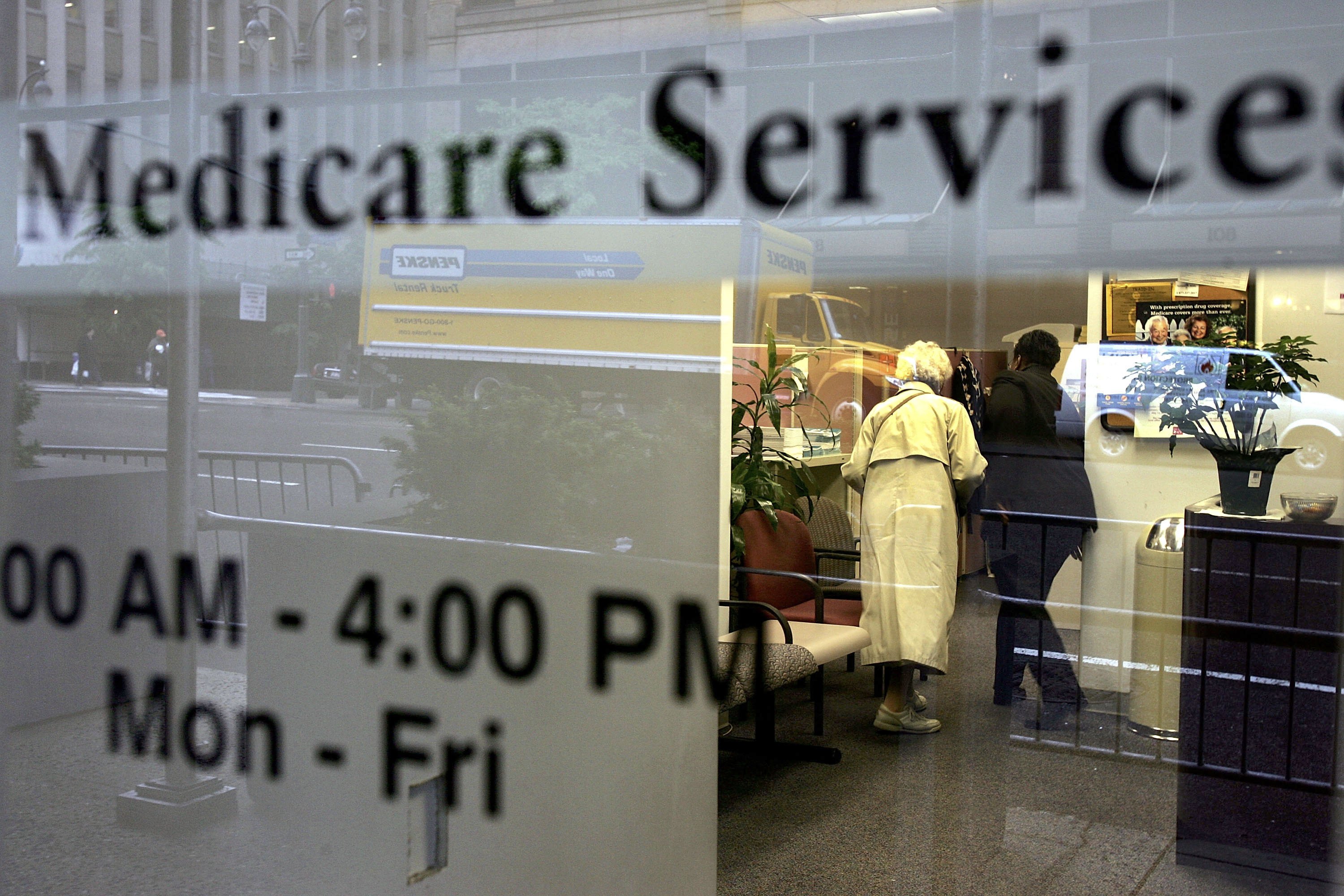 NEW YORK - MAY 15:  Two people walk inside a Medicare Services office on the last day for enrollment in the Medicare Part D program May 15, 2006 in New York City. According to official reports, approximately thirty seven million Americans, as of last week, had signed up for Medicare Part D, leaving an estimated seven million eligible seniors without drug coverage as they have yet to enroll in the drug plan.  (Photo by Spencer Platt/Getty Images)