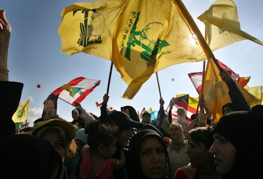 BEIRUT, LEBANON- SEPTEMBER 22: Hezbollah supporters wave flags during a ''Victory over Israel'' rally in Beirut's suburbs on September 22, 2006 in Beirut, Lebanon. Hezbollah leader Sayyed Hassan Nasrallah reportedly said that Hezbollah would not disarm until a Lebanese government capable of protecting the country was in place during the rally.  (Photo by Salah Malkawi/Getty Images)
