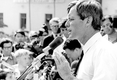 a black and white photo of a man speaking into a microphone