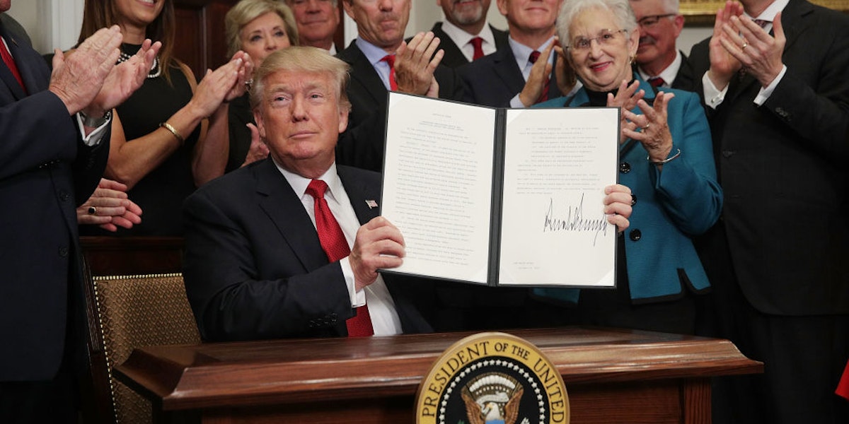 WASHINGTON, DC - OCTOBER 12:  U.S. President Donald Trump shows an executive order after he signed it as Sen. Rand Paul (R-KY), Vice President Mike Pence, Rep. Virginia Foxx (R-NC) and Secretary of Labor Alexander Acosta look on during an event in the Roosevelt Room of the White House October 12, 2017 in Washington, DC. President Trump signed the executive order to loosen restrictions on Affordable Care Act 