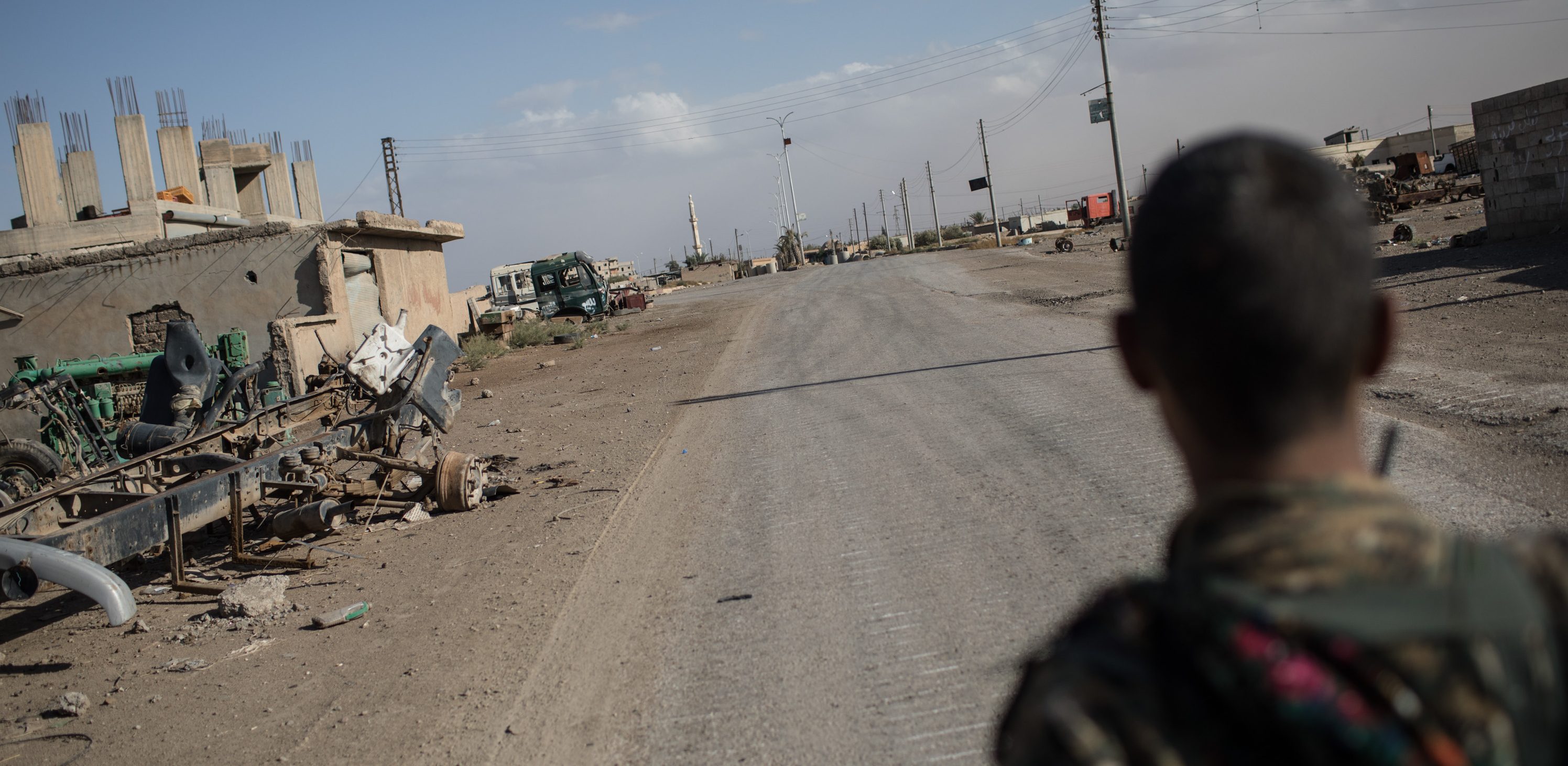 RAQQA, SYRIA - OCTOBER 30:  A fighter of the Syrian Democratic Forces (SDF) stands in an an empty street in the western neighborhood of Jazrah on the outskirts of Raqqa on October 30, 2017 in Raqqa, Syria. Following three and a half months of fighting Raqqa was liberated from the control of ISIL on October 19. Since then the city and surrounding neighborhood's have become a ghost town after being sealed off to civilians due to masses of landmines throughout the city.  (Photo by Chris McGrath/Getty Images)